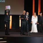 طفل المستعمرة في لحظة مؤثرة بعد فوز الفيلم بجائزة النجمة البرونزية ويشاركه المخرج محمد رشاد بمهرجان الجونة الفيلم المصري المستعمرة